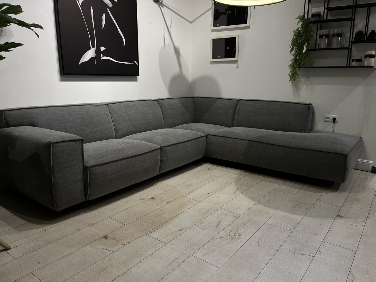 Duża elegancka sofa modułowa Vesta. Ciekawa szara bawełniana tkanina. Wygodny narożnik wyróżniający się spośród innych dekoracyjnym szwem francuskim