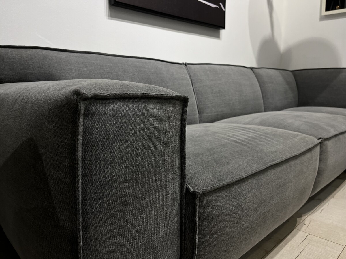 Sofa narożna w tkaninie naturalnej z efektem Stone Washed. Wygodny szeroki podłokietnik z dekoracyjnym szwem zewnętrznym.